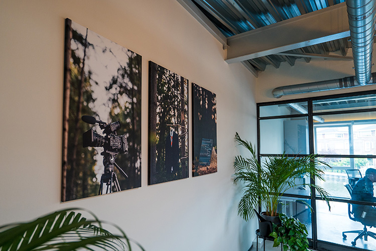 drie foto's op canvas opgehangen op een kantoor